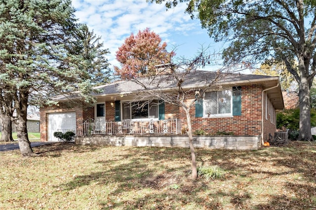 ranch-style home featuring a garage, covered porch, and a front yard