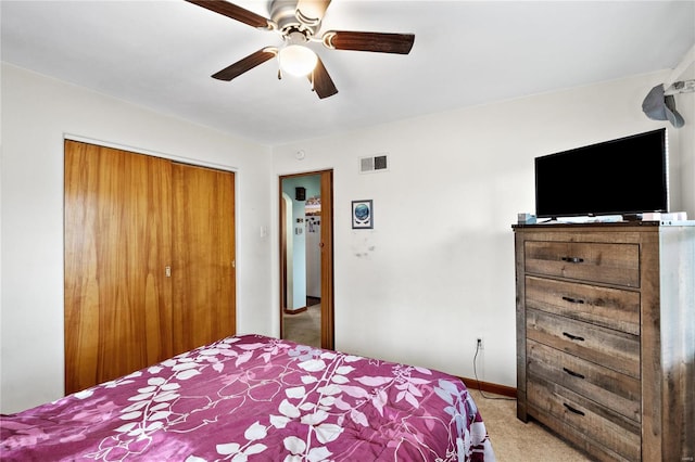 carpeted bedroom featuring a closet and ceiling fan