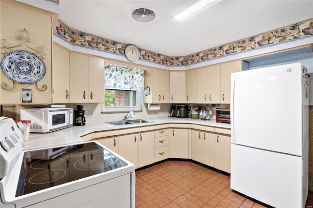 kitchen featuring white appliances, sink, cream cabinets, and decorative backsplash