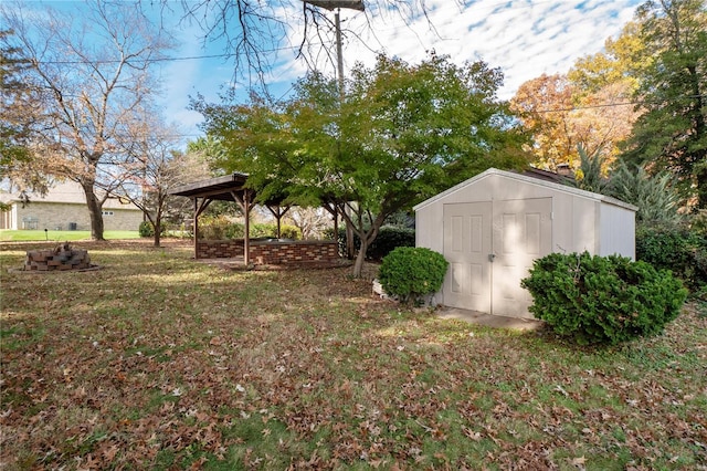 view of yard with a fire pit, a storage unit, and a gazebo