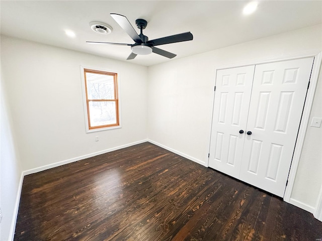 unfurnished bedroom with dark wood-type flooring, ceiling fan, and a closet