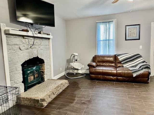 living room featuring a wood stove and ceiling fan