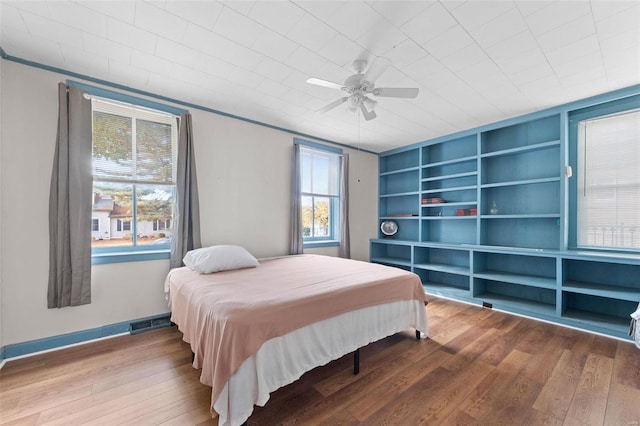 bedroom featuring ornamental molding, hardwood / wood-style floors, and ceiling fan