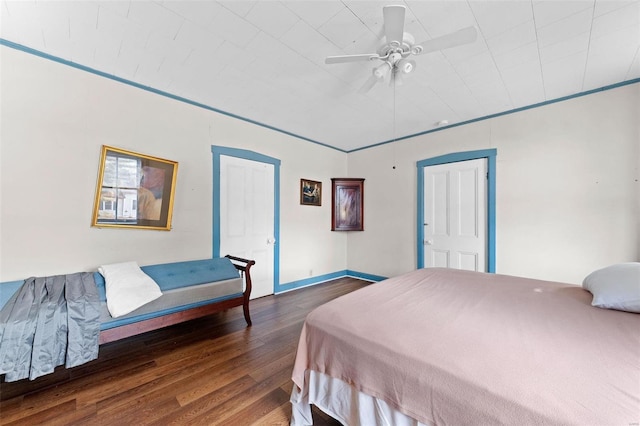 bedroom with dark wood-type flooring, ceiling fan, and crown molding