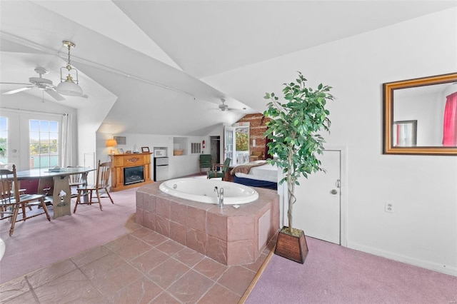 bathroom with tiled bath, lofted ceiling, ceiling fan, and tile patterned floors