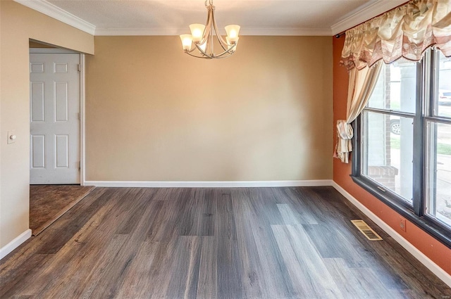 empty room featuring dark hardwood / wood-style floors, crown molding, and an inviting chandelier