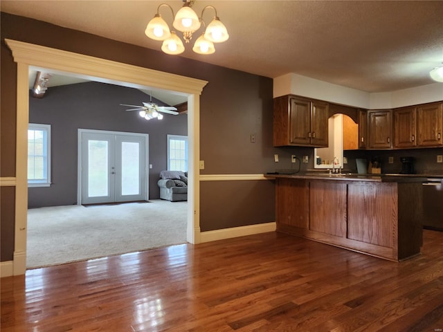 kitchen with french doors, ceiling fan with notable chandelier, stainless steel dishwasher, dark hardwood / wood-style flooring, and kitchen peninsula