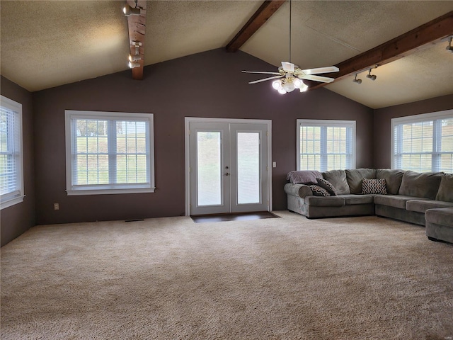 unfurnished living room featuring carpet flooring, french doors, a textured ceiling, and plenty of natural light