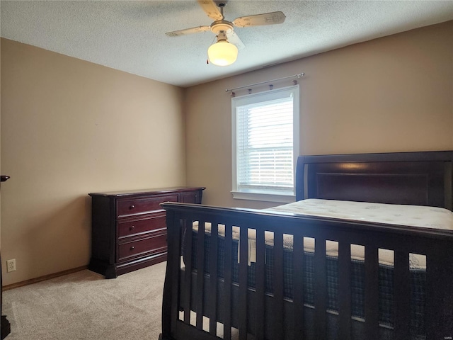 carpeted bedroom with ceiling fan and a textured ceiling