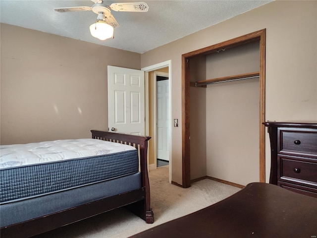 bedroom featuring light carpet, a textured ceiling, a closet, and ceiling fan