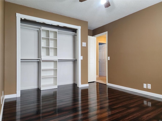 unfurnished bedroom featuring ceiling fan, dark hardwood / wood-style flooring, a textured ceiling, and a closet