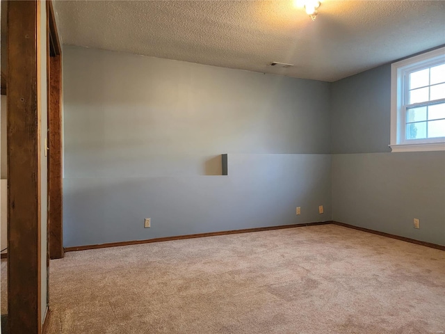 carpeted empty room featuring a textured ceiling