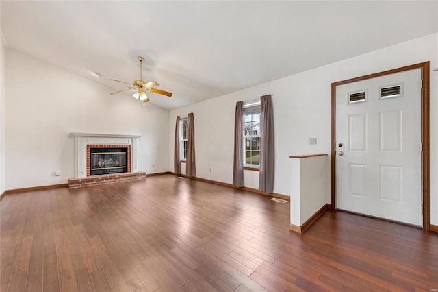 unfurnished living room with vaulted ceiling, ceiling fan, a fireplace, and dark hardwood / wood-style floors