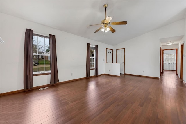 unfurnished room with a healthy amount of sunlight, lofted ceiling, and dark hardwood / wood-style floors