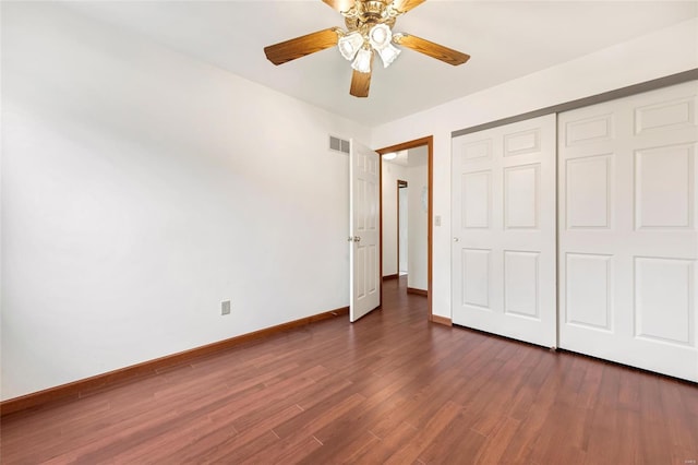 unfurnished bedroom with ceiling fan, a closet, and dark wood-type flooring