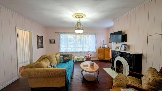 living room featuring ornamental molding, wood walls, and dark hardwood / wood-style floors