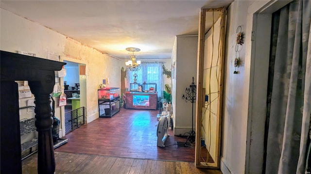 hallway with dark wood-type flooring and a notable chandelier