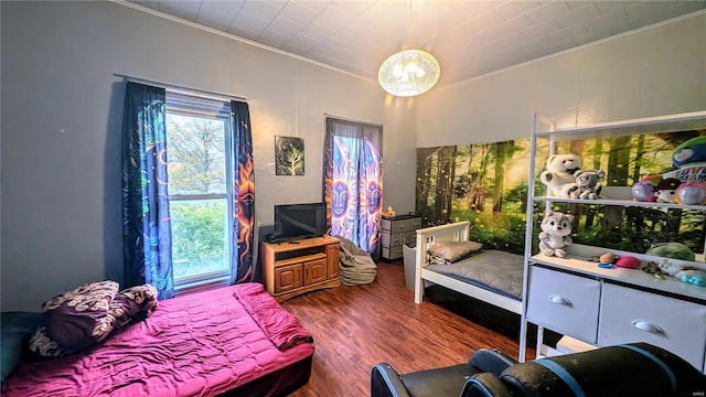 bedroom with dark hardwood / wood-style flooring and crown molding