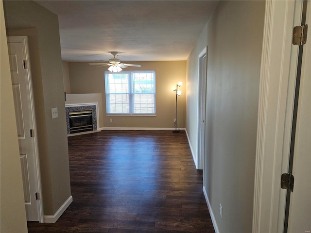 unfurnished living room with ceiling fan and dark wood-type flooring