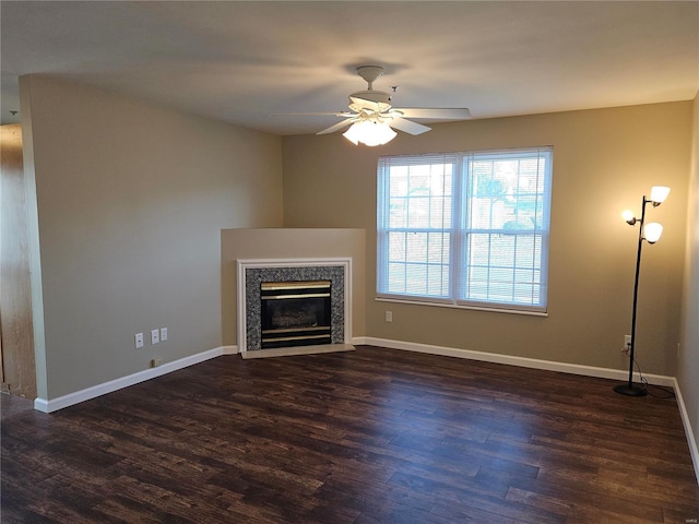 unfurnished living room featuring a fireplace, dark hardwood / wood-style flooring, and ceiling fan