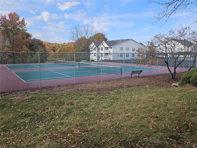 view of tennis court featuring a lawn