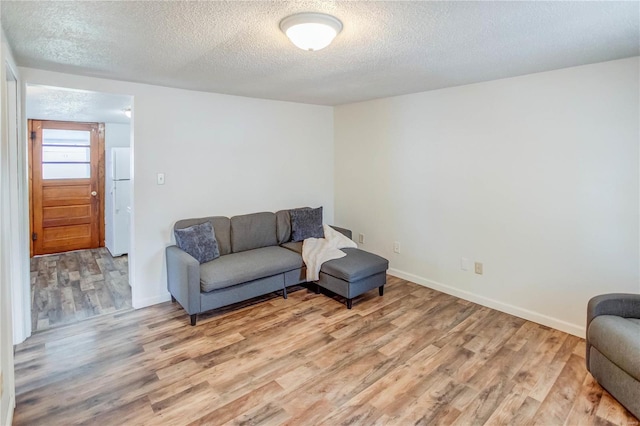 living room featuring a textured ceiling and light hardwood / wood-style flooring