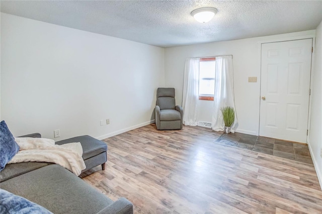 living area featuring light hardwood / wood-style floors and a textured ceiling