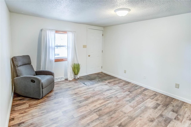 sitting room featuring a textured ceiling and light hardwood / wood-style flooring