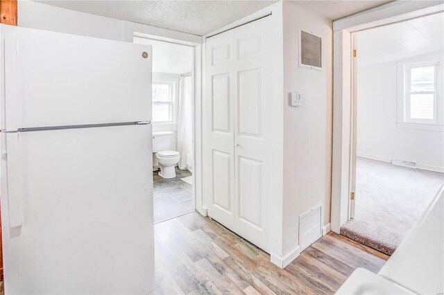 bathroom with hardwood / wood-style flooring, a textured ceiling, and toilet