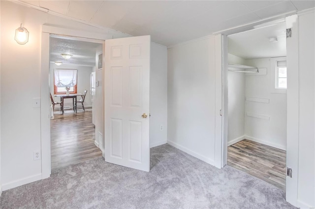 unfurnished bedroom featuring light wood-type flooring, multiple windows, and a closet