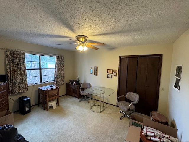 sitting room featuring ceiling fan, a textured ceiling, and light carpet