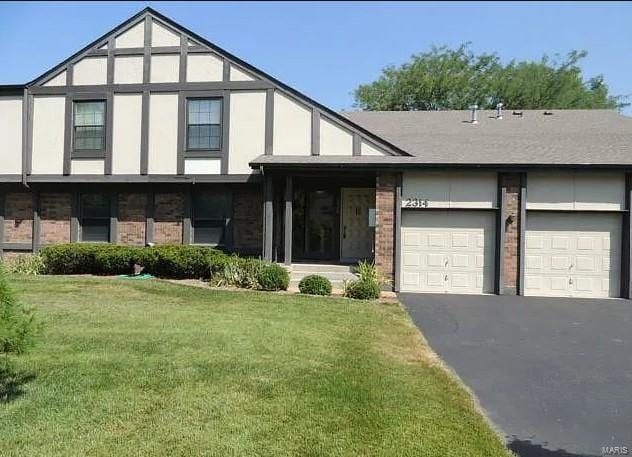 view of front of house with a garage and a front lawn