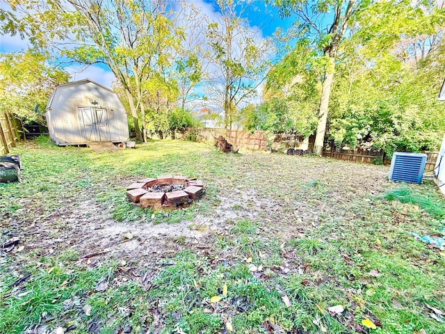 view of yard with a shed and a fire pit