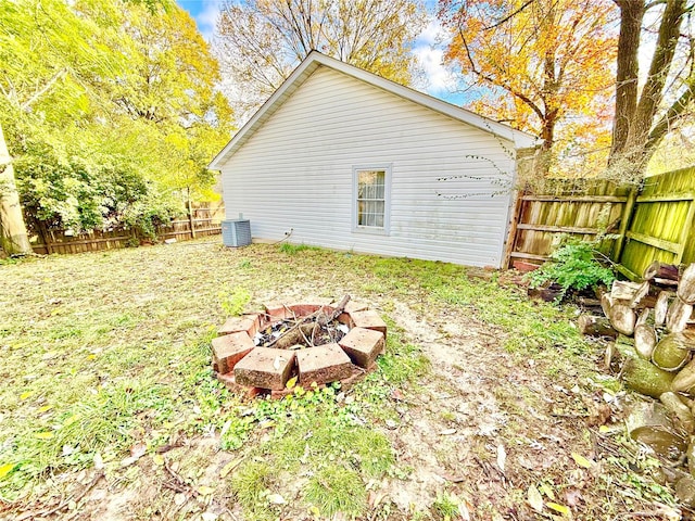 view of yard with central air condition unit and a fire pit