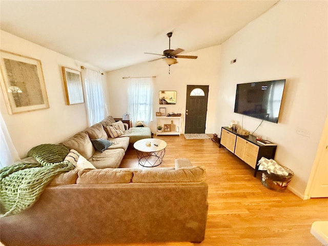 living room with hardwood / wood-style flooring, ceiling fan, and vaulted ceiling