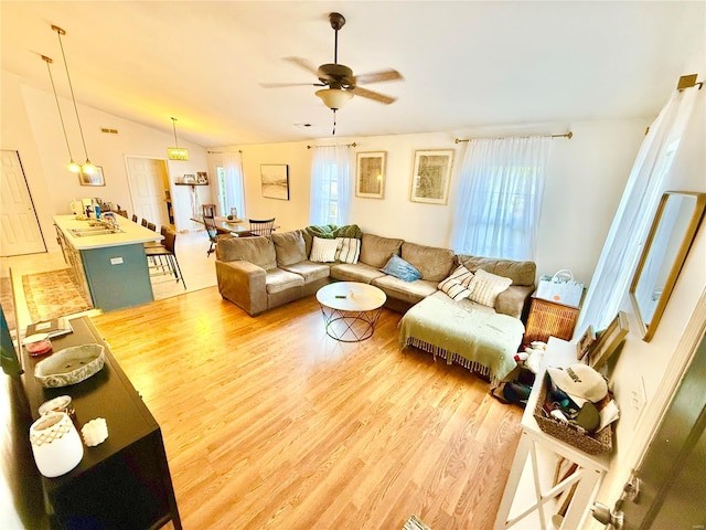 living room with hardwood / wood-style floors, ceiling fan, and lofted ceiling