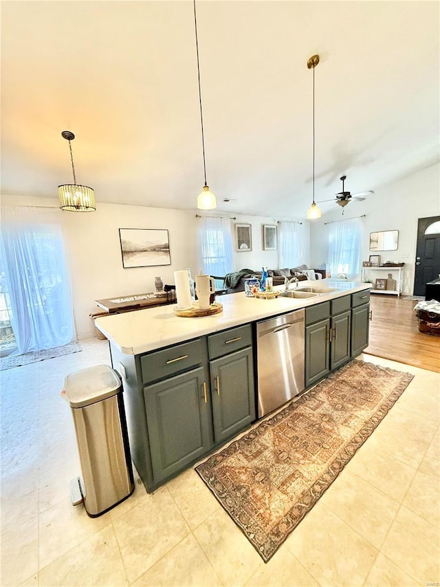 kitchen featuring stainless steel dishwasher, a wealth of natural light, hanging light fixtures, and an island with sink