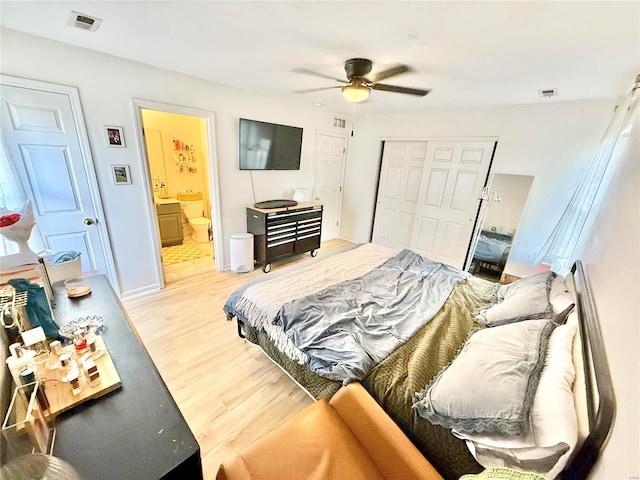 bedroom with light hardwood / wood-style floors, ceiling fan, ensuite bath, and a closet