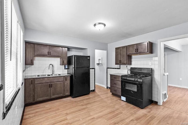 kitchen with black appliances, light wood-type flooring, sink, and dark brown cabinets