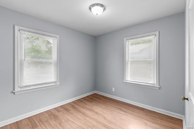 spare room featuring a wealth of natural light and light hardwood / wood-style flooring