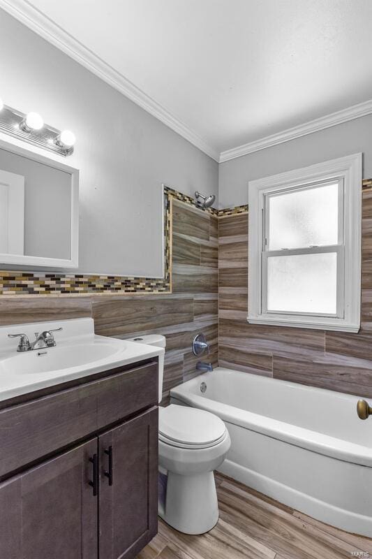 full bathroom with washtub / shower combination, ornamental molding, hardwood / wood-style floors, toilet, and tile walls