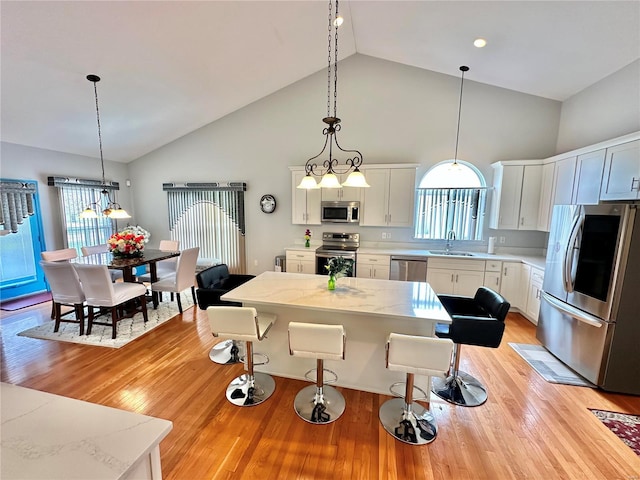 kitchen featuring pendant lighting, white cabinetry, light hardwood / wood-style flooring, and appliances with stainless steel finishes