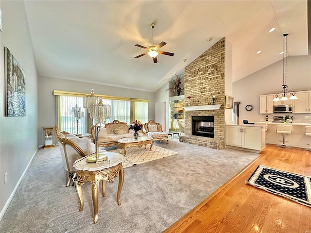 living room with high vaulted ceiling, ceiling fan, light hardwood / wood-style floors, and a brick fireplace