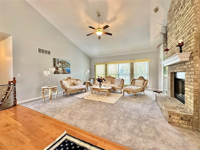 living room featuring hardwood / wood-style floors, ceiling fan, high vaulted ceiling, and a brick fireplace