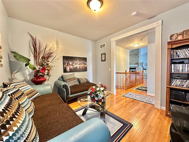 living room with hardwood / wood-style floors and a stone fireplace