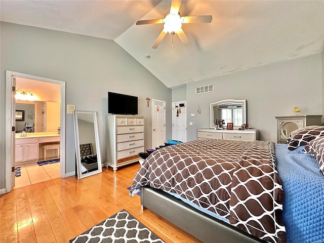 bedroom with light hardwood / wood-style floors, ceiling fan, lofted ceiling, and ensuite bathroom