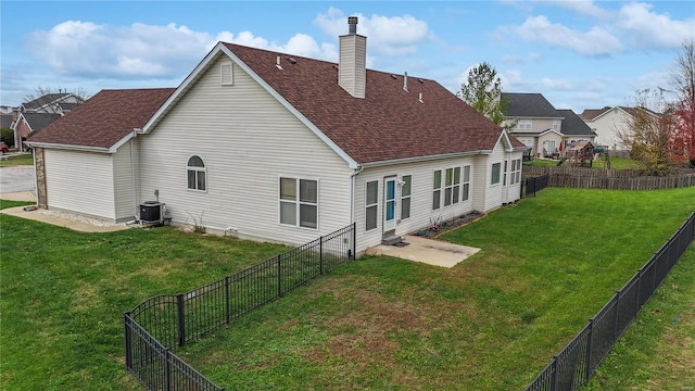 back of property with a patio, a lawn, and central AC