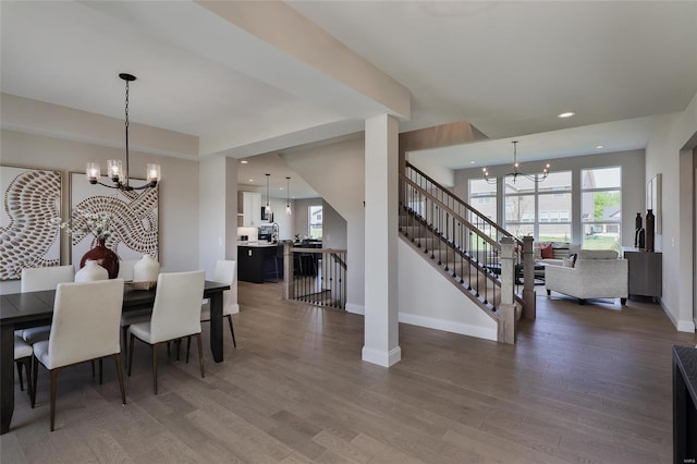 dining space with hardwood / wood-style floors and a chandelier