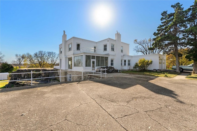 rear view of property featuring a sunroom