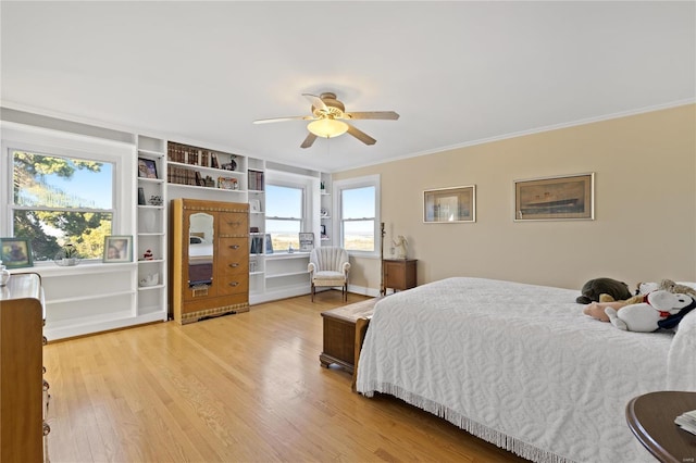 bedroom featuring hardwood / wood-style flooring, ceiling fan, and crown molding